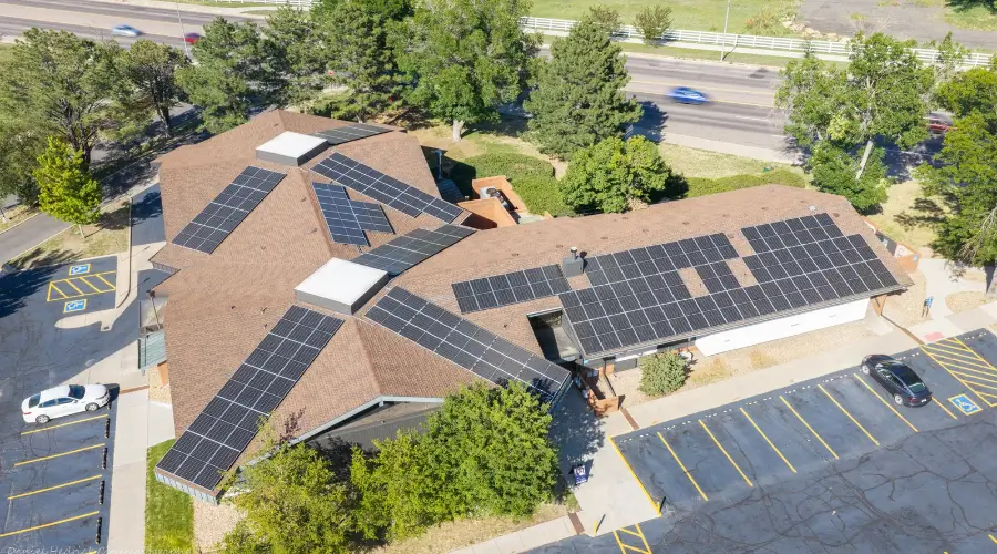 Aerial view of commercial solar panels installed across multiple roof sections at 10001 Washington