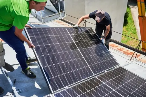 Technician removing solar panels from a residential roof